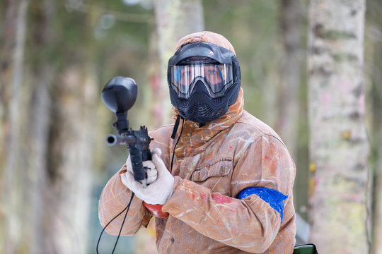 Paintball game in winter. Cool shooter with marker.