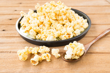 Salt popcorn on the wooden table, selective focus