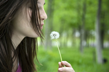 Young women blowing dandelion