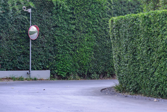 Traffic convex mirror with security camera at street corner.