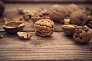 Walnut kernels and whole walnuts on rustic old wooden table