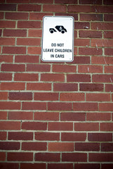 Fototapeta na wymiar do not leave children in car sign on brick wall background