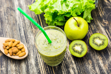 Healthy green smoothie with kiwi and apples on  wooden background
