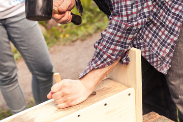 Wooden birdhouse is under construction, carpenter