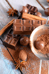 Chocolate sweets with powder on wooden background