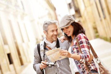 Cheerful couple looking at map, week-end tour