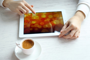 Woman using digital tablet on table close up