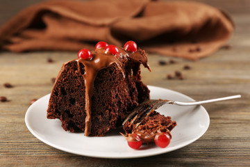 Piece of chocolate cake with snowball tree berries on a table