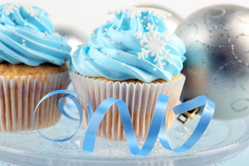 Few tasty blue cupcakes with decorations on light background
