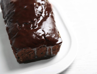 Chocolate cake with icing on white table