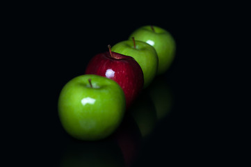 Red and green apple fruit isolated on black background in row