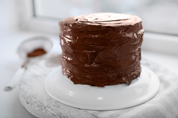 Chocolate cake on a plate on unfocused background