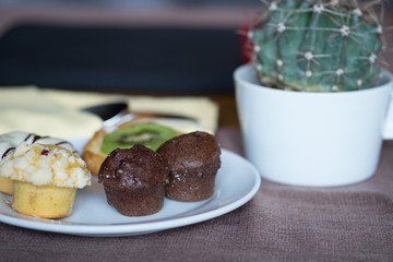 Fresh and hot chocolate bun / Fresh and hot chocolate bun, muffin, doughnut and kiwi croissant on tablecloth served in restaurant