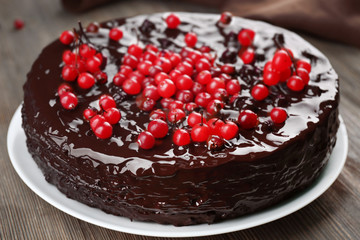Chocolate cake with cranberries on wooden table, closeup