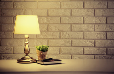 Night lamp on the locker on white brick wall background