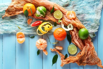 Fresh citrus fruits with green leaves on wooden table closeup