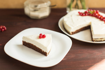 yoghurt cheesecake with fresh red currants on wooden table
