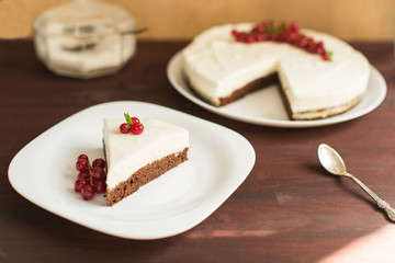 yoghurt cheesecake with fresh red currants on wooden table