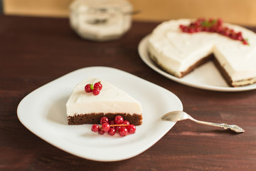 yoghurt cheesecake with fresh red currants on wooden table
