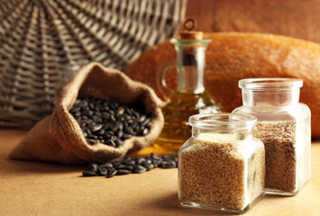 Composition of seeds, bread and oil on beige background, closeup