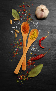 Different spices and spoons on wooden table