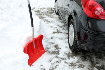 Winter concept. Red shovel for cleaning the driveway of snow