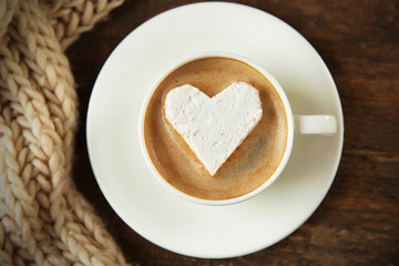 Cup of coffee with marshmallow on wooden table