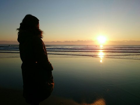 朝陽と海と女性