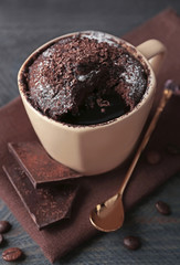Chocolate fondant cake in cup on wooden table closeup