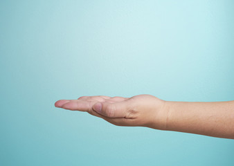 Close-up of  hand isolated on blue background. Palm up