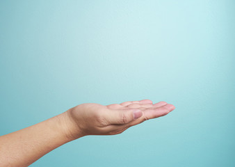 Close-up of  hand isolated on blue background. Palm up