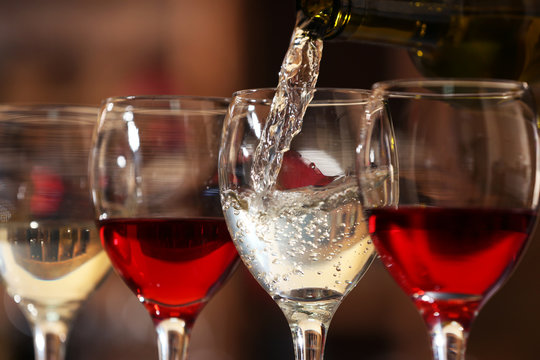 White wine pouring into wine glass, closeup