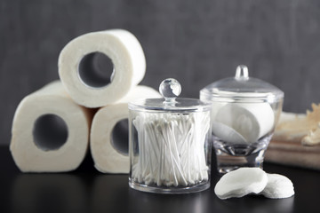 Bathroom set with paper towels, ear sticks and sponges on grey background