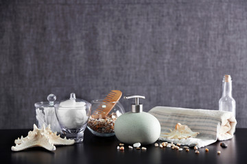 Bathroom set with dispenser, wooden comb and towel on grey background