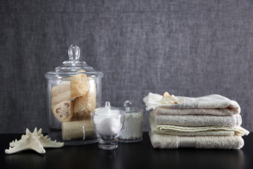Bathroom set with towels, sponges and wisps on grey background