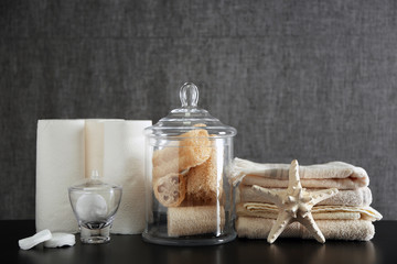 Fototapeta na wymiar Bathroom set with towels, wisps and sponges on grey background