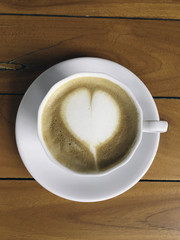 A cup of cappuccino on a wood background