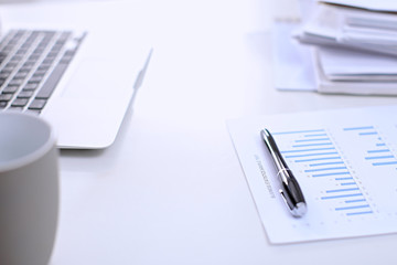 .Office workplace with a laptop and financial documents on the light reflecting table
