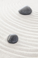 Fototapeta na wymiar Two black stones in sand, spa or zen concept