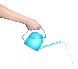 Obraz premium Female hand pouring from blue plastic watering can, isolated on white