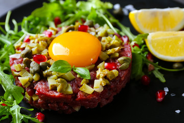 Beef tartare served in a round plate, close up
