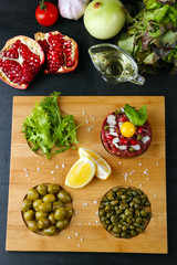 Beef tartare served on a wooden board, top view