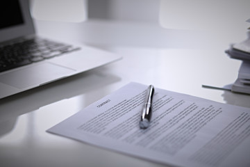 .Office workplace with a laptop and contract document on the light reflecting table
