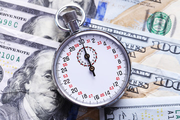 Stopwatch on dollar banknotes, close up. Time is money concept