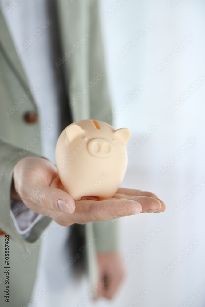 Wall mural man holding piggy bank in hand closeup