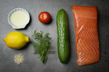 Tasty ingredients of salmon tartare on steel table, flat lay