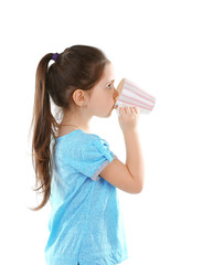 Little girl drinking water from cup, isolated on white