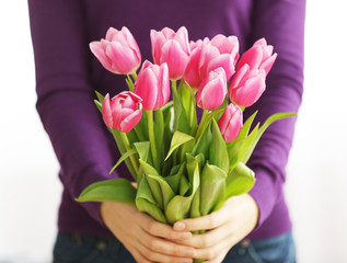 Bouquet of pink tulips in hands of beautiful young  girl, close up