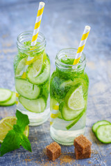 Lime, cucumber lemonade in bottles with straws
