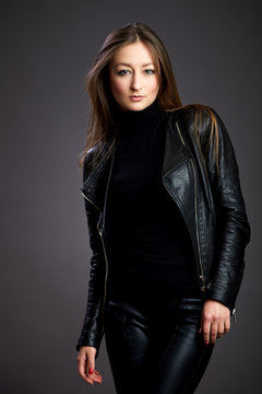 Attractive young woman alluring in fitting leather suit. Beauty, fashion